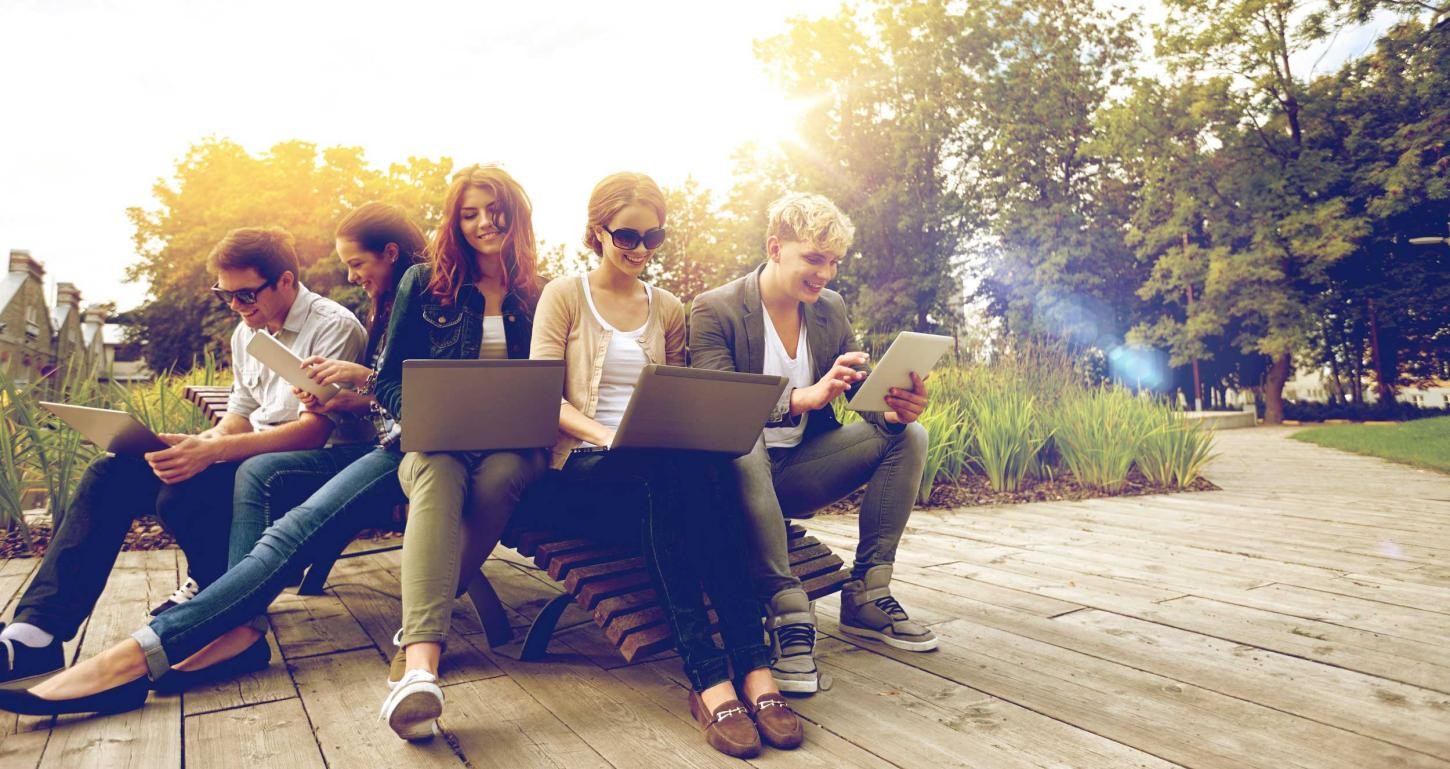 Studierende arbeiten im Freien an Laptops
