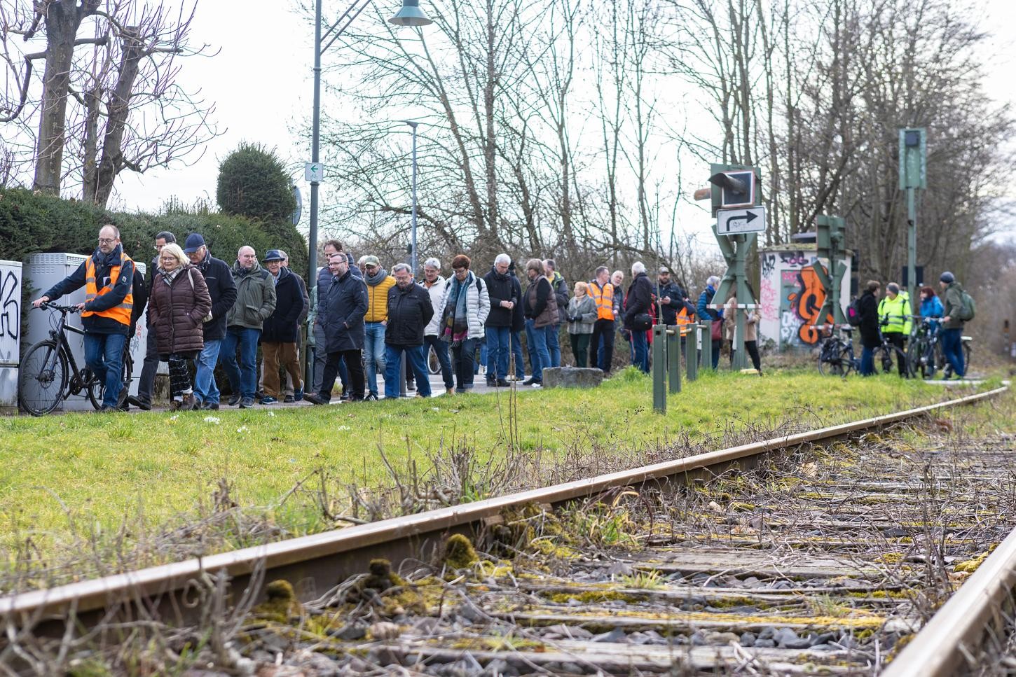 Menschen spazieren am Gleis