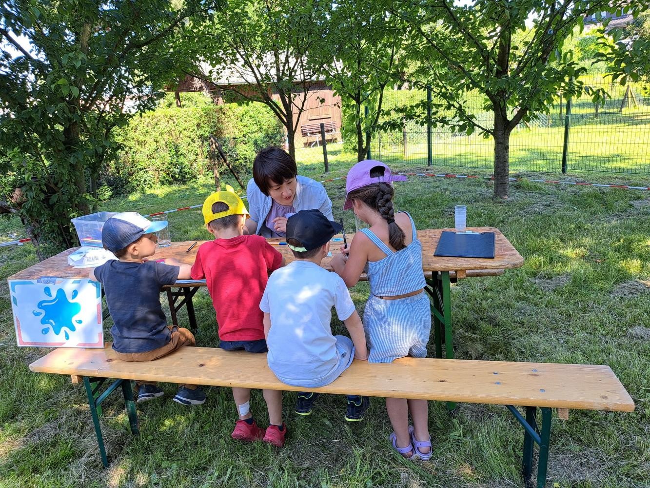 Vier Kinder am Maltisch mit Betreuung
