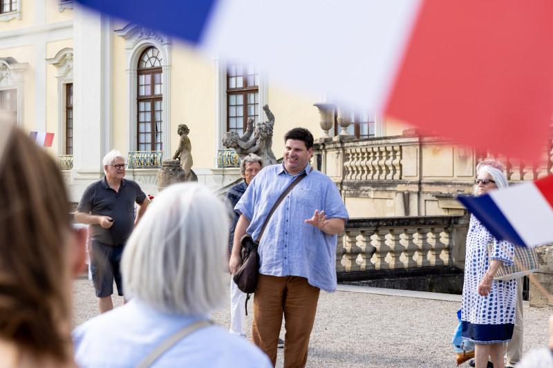 Gästeführer und französische Flagge vor dem Residenzschloss Ludwigsburg