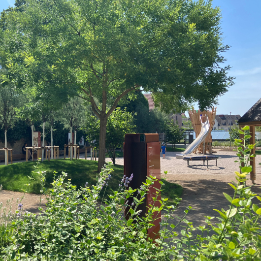 Park mit Bäumen, Grünflächen und Spielplatzelementen