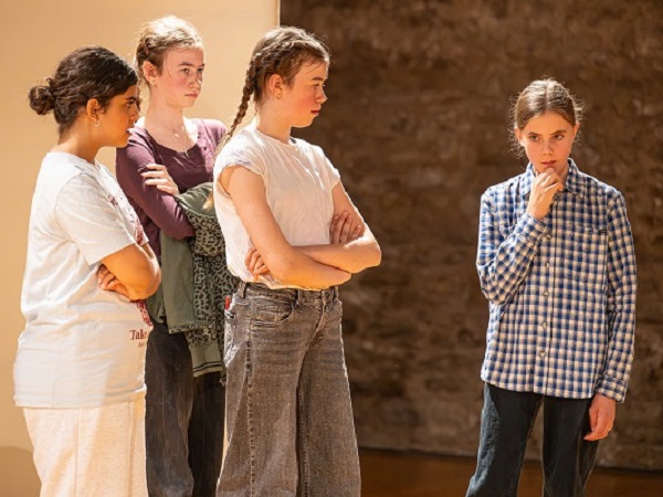 3 Mädchen stehen einem anderen Mädchen gegenüber - Theaterpädagogik