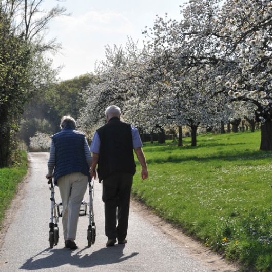 Älteres Paar mit Rollator beim Spaziergang