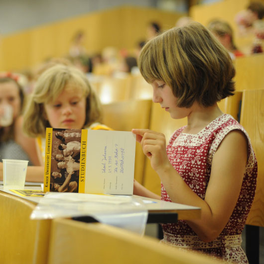 Ein Mädchen liest in einem Hörsaal in einem Buch