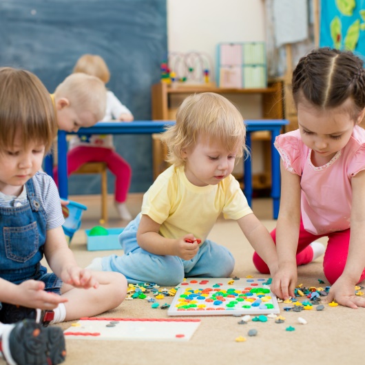 Spielende Kinder in einer Betreuungseinrichtung – Link zur Seite Kinderbetreuung