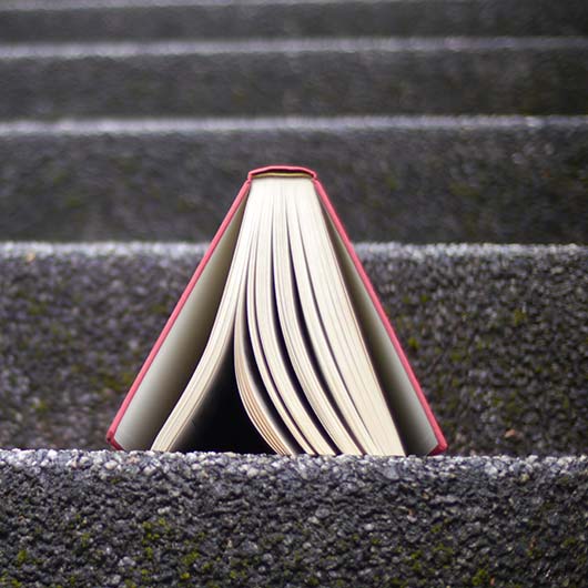 Aufgeschlagenes Buch auf einer Außentreppe