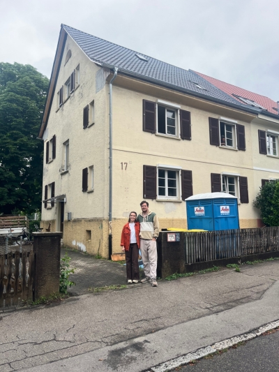 Ehepaar steht vor ihrem sanierungsbedürftigen Haus