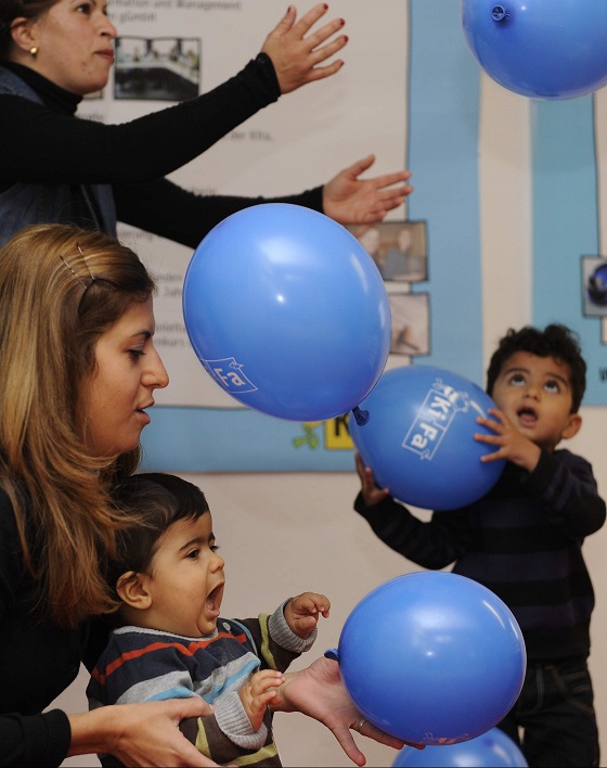 Kinder die mit blauen Luftballons spielen
