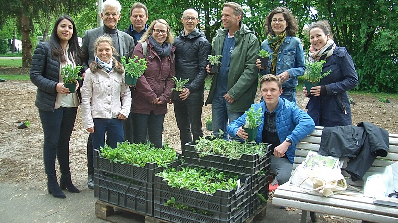 Gruppenbild - Personen halten Jungspflanzen in den Händen