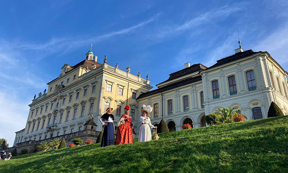 Drei Stadtführerinnen im Kostüm vor dem Residenzschloss