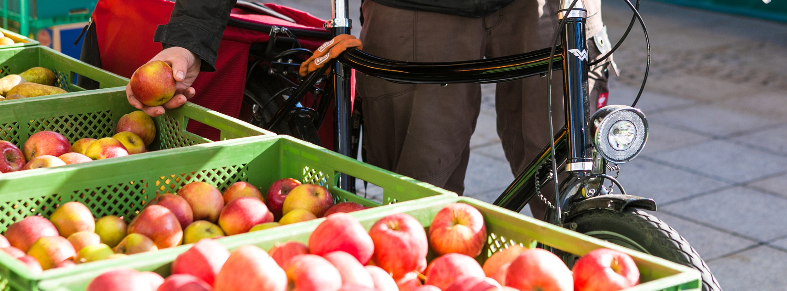 Mann mit Fahrrad kauft Äpfel am Marktstand in Ludwigsburg