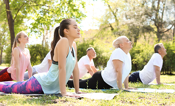Menschen im Park beim Yoga.