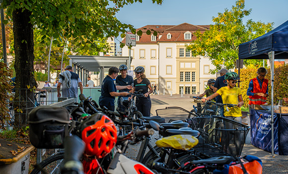 Menschen schieben ihre Fahrräder auf einen Fahrradparkplatz auf dem Rathaushof.