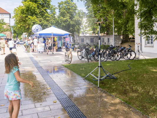 Kind kühlt sich an Wassersprinkler ab