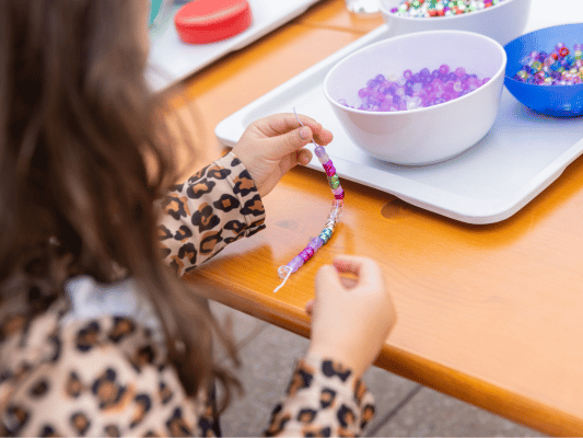 Mädchen bastelt eine Kette