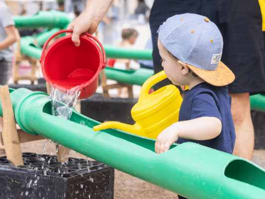 Kind spielt an der Wasserbaustelle