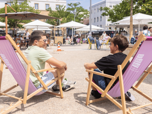 Menschen sitzen auf Liegestühlen
