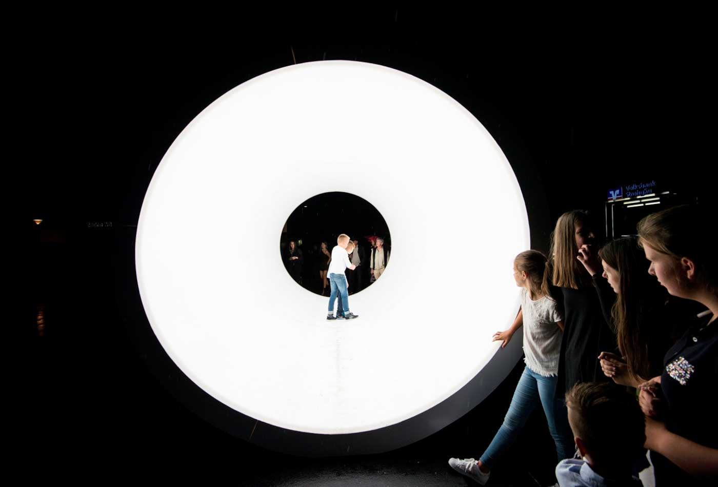 Eine Besucherin steht in einem weißen Lichtkreis.