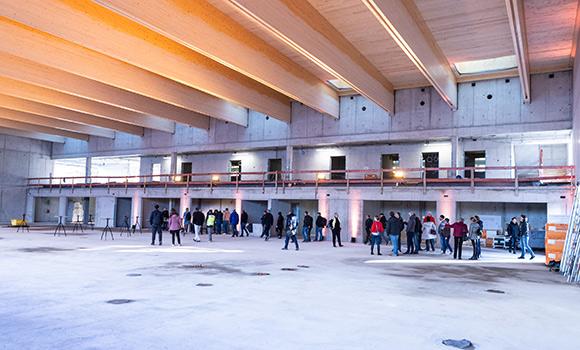 Blick ins Innere der Oststadthalle. In der Halle stehen circa 35 Personen.