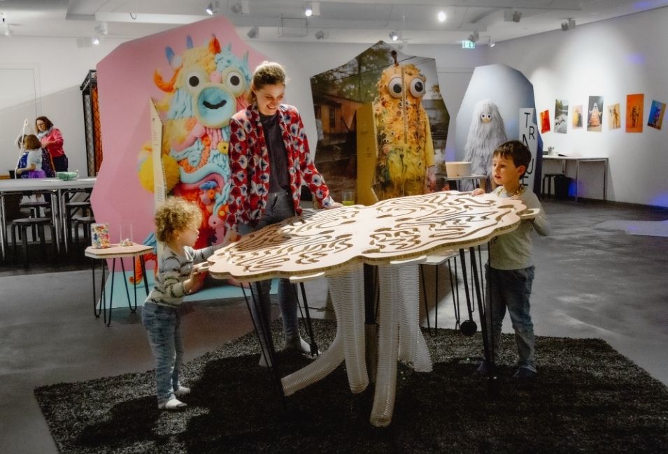 Ein Frau betrachtet mit zwei kleinen Kindern ein Ausstellungstück.