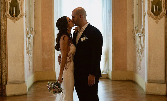 Das Brautpaar küsst sich in einem prunkvollen Saal des Residenzschlosses.