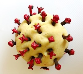 Kugelförmiges Objekt mit beigem Grund und roten Spitzen, das einem Virusmodell ähnelt.