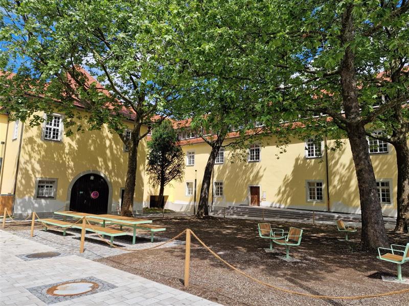 Neu angelegte Holz-Tische und Sitze auf dem sonnigen Ehrenhof