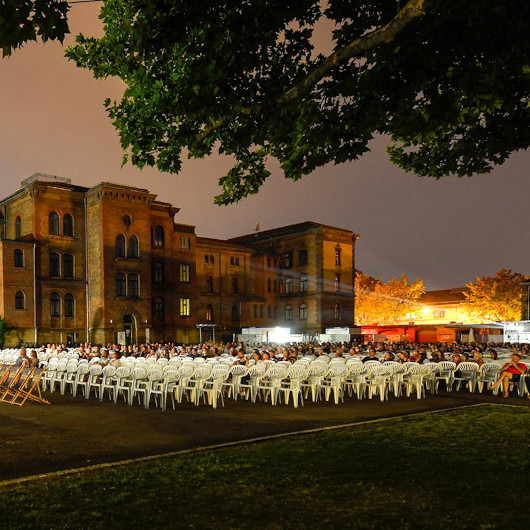 Der Innenhof der Karlskaserne ist erleuchtet und mit zahlreichen weißen Stuhlreihen bestückt.