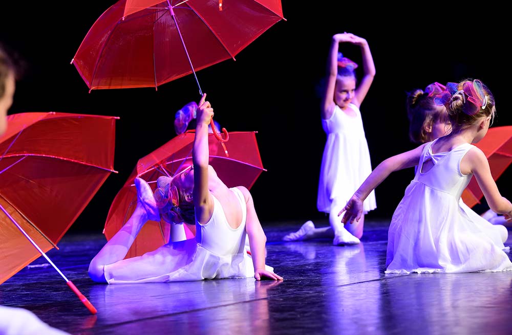 Mädchen beim Tanz mit Regenschirmen