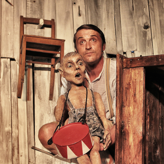 Ein Schauspieler steht mit einer Puppe auf der Bühne des Theatersommers.