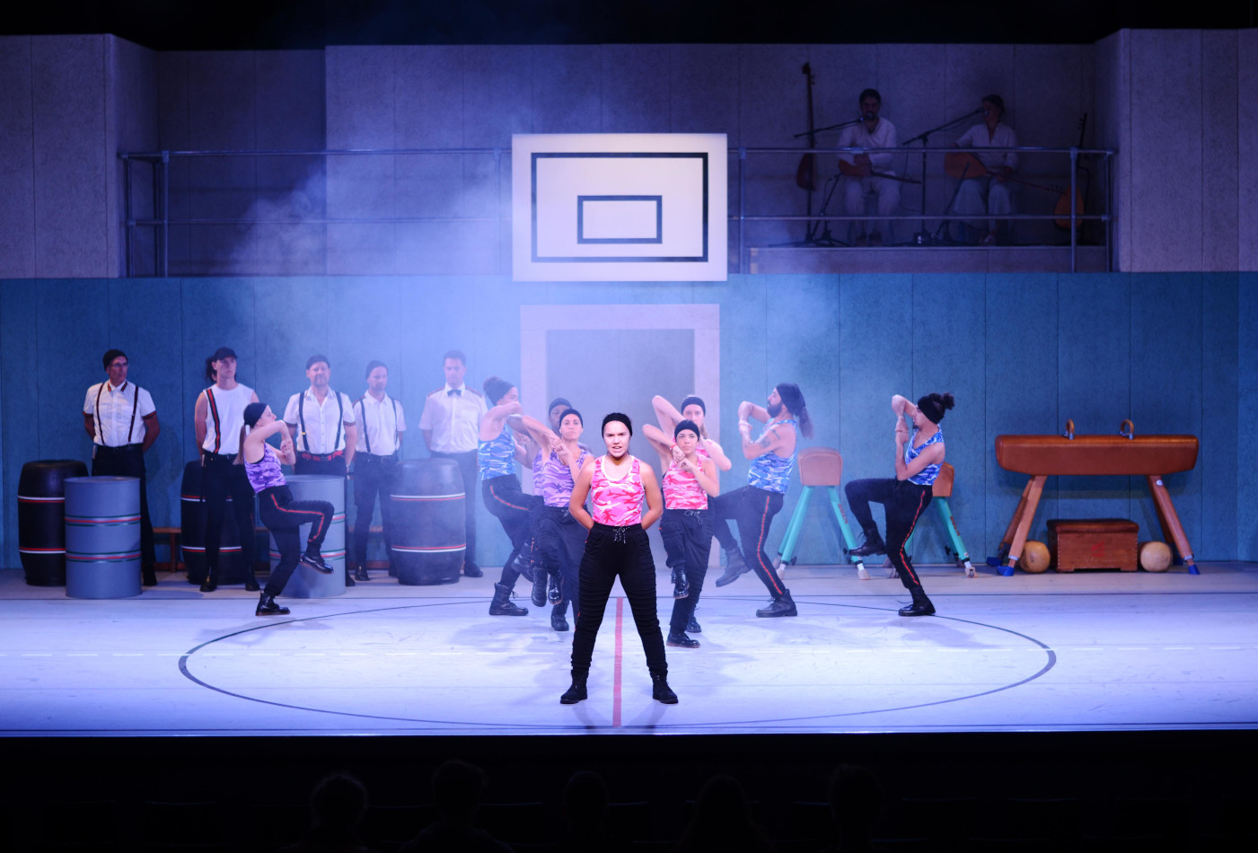 Eine Gruppe junger Menschen steht auf einer Bühne und tanzt.