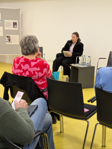 Die Autorin liest aus ihrem Werk, während das Publikum gespannt zuhört