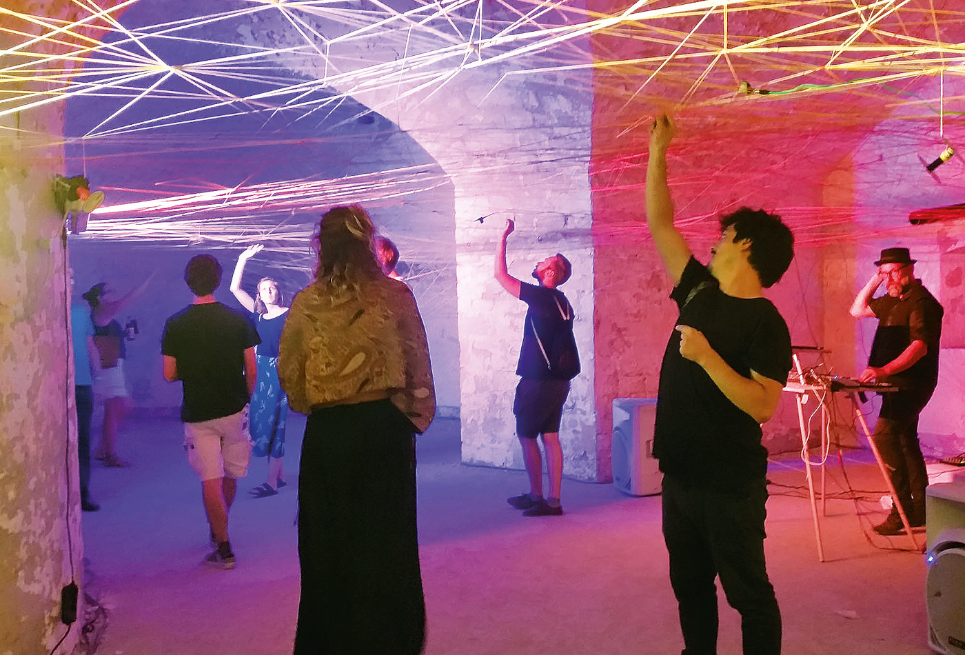 Junge Menschen stehen unter einem Kunstwerk aus einer Netzstruktur der Künstlerin Ines Fiegertz