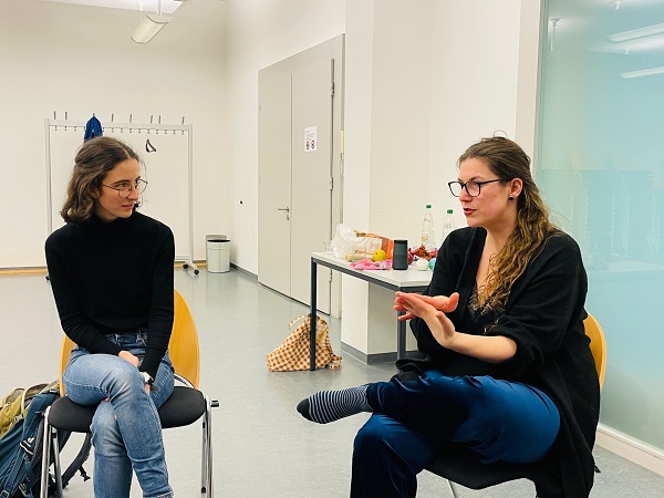 zwei Frauen sitzen auf Stühlen und unterhalten sich