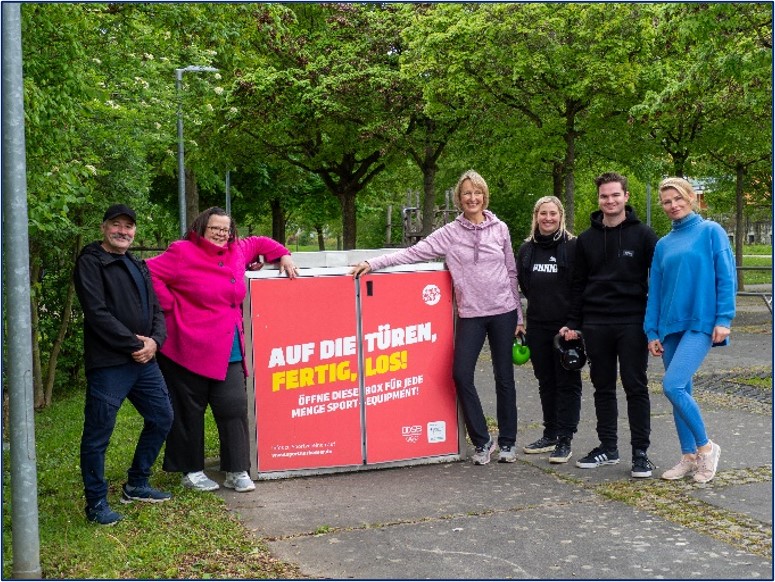 Erstbürgermeisterin Schmetz steht mit fünf Personen am Sportbox