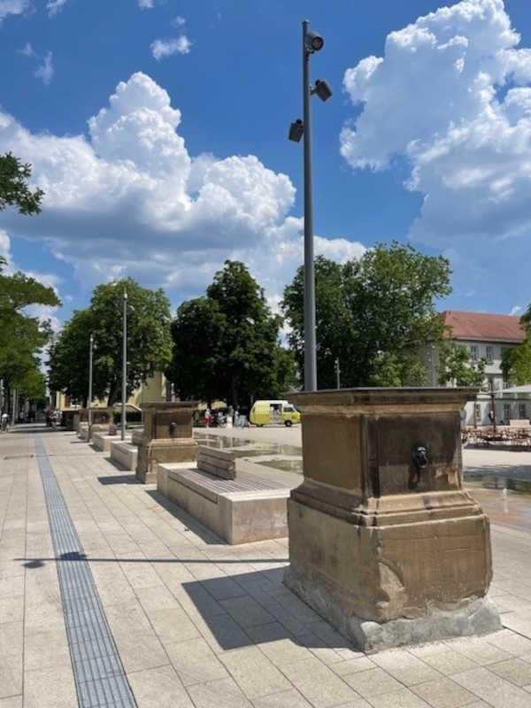 Eine Person steht auf einen Gerüst und steckt etwas in eine große Stofftasche.