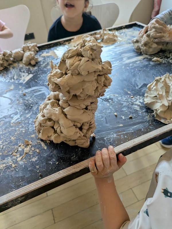 Kinder am Tisch mit kreativen Tonkunstwerken