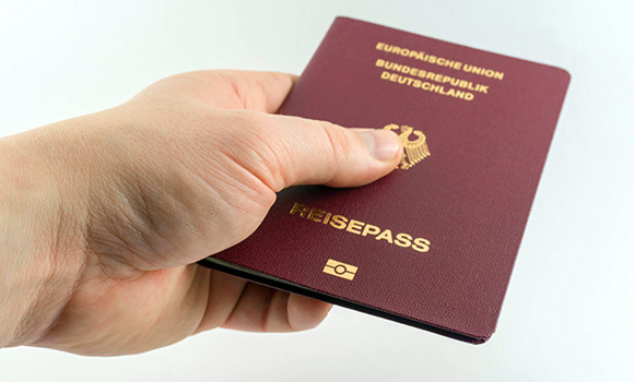 Eine Hand hält einen Reisepass.