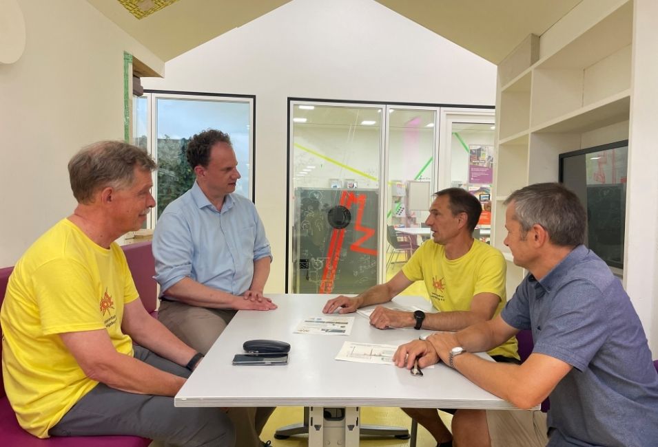 Vier Männer im Gespräch an einem Tisch