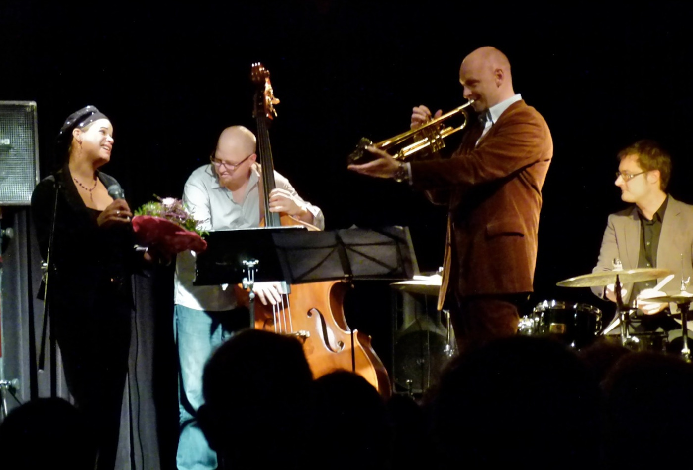 Jazzmusiker stehen auf einer Bühne.